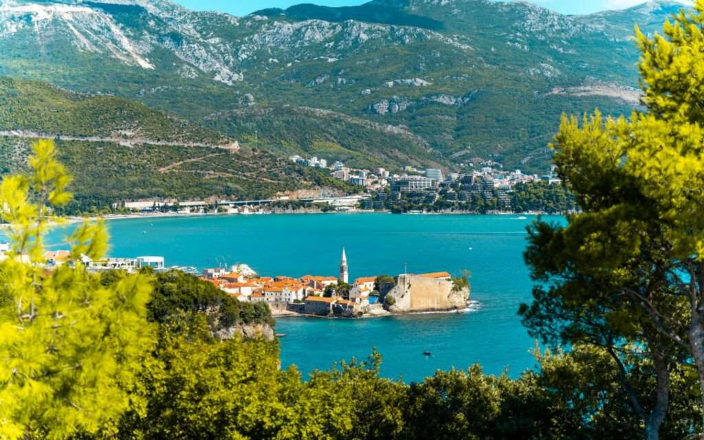 An old town on a peninsula along the Montenegrin coast, mountains behind