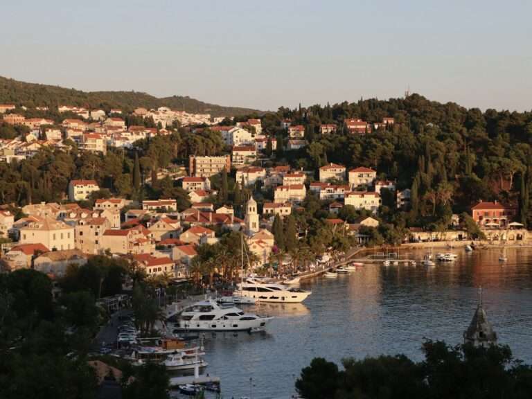 Cavtat's bay and waterfront at golden hour, ringed by wooded hills